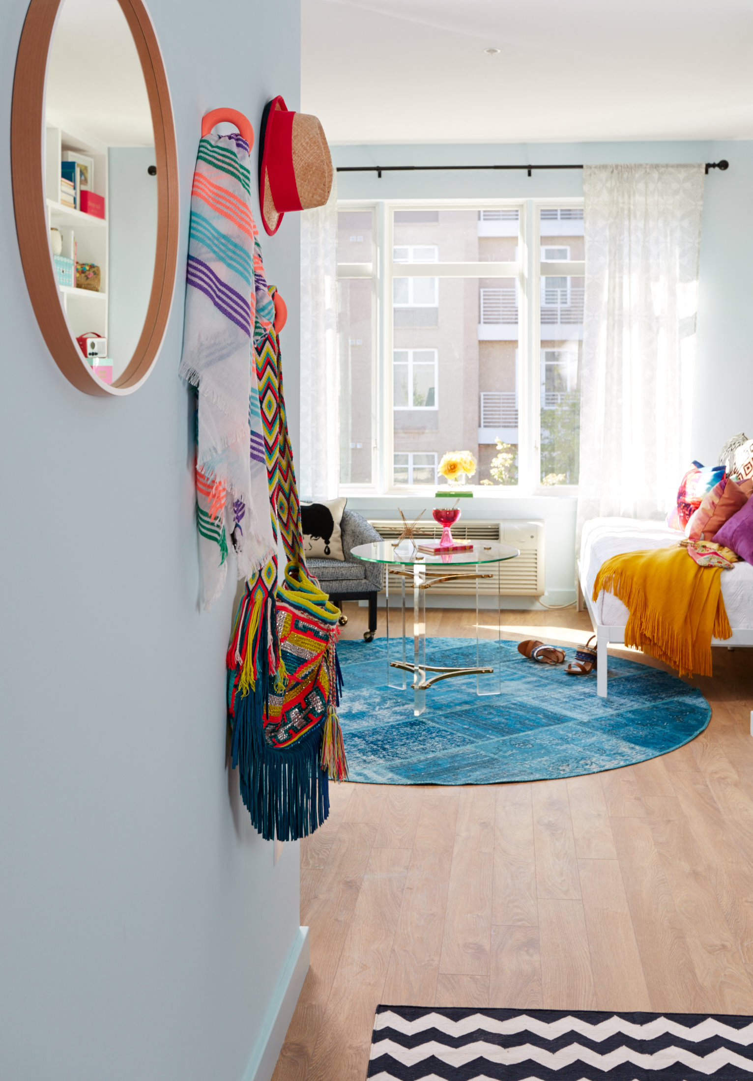 a living room with a rug and a mirror on the wall