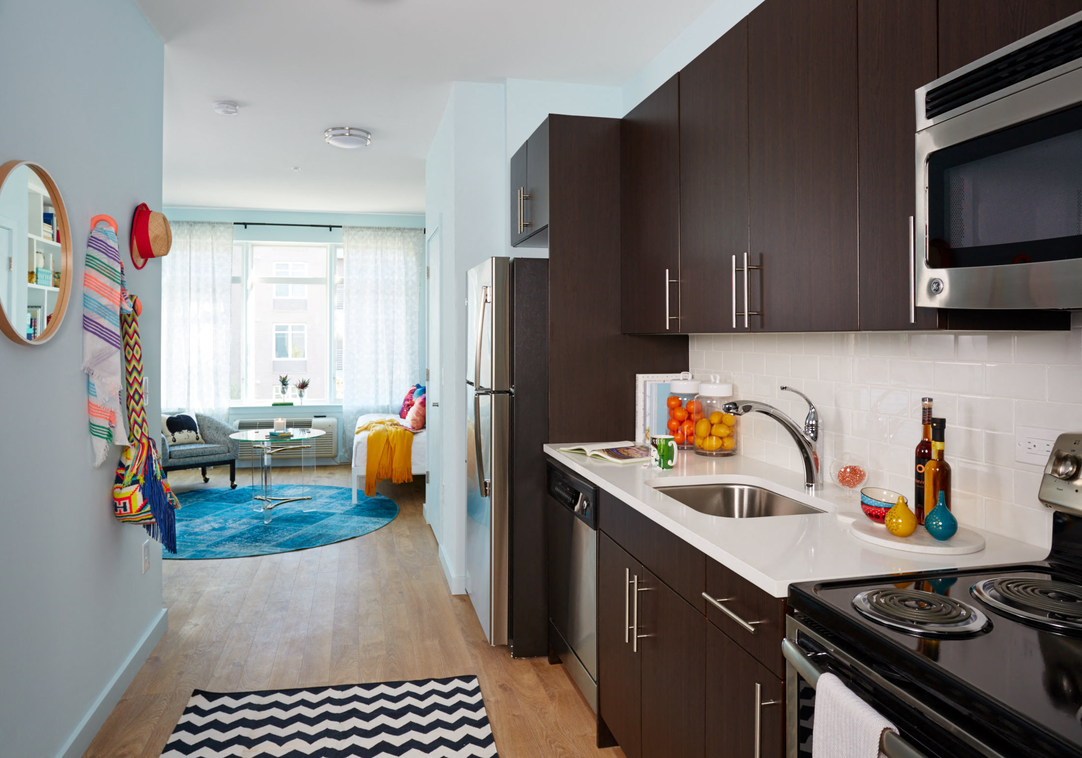 a kitchen with a sink and refrigerator and a living room