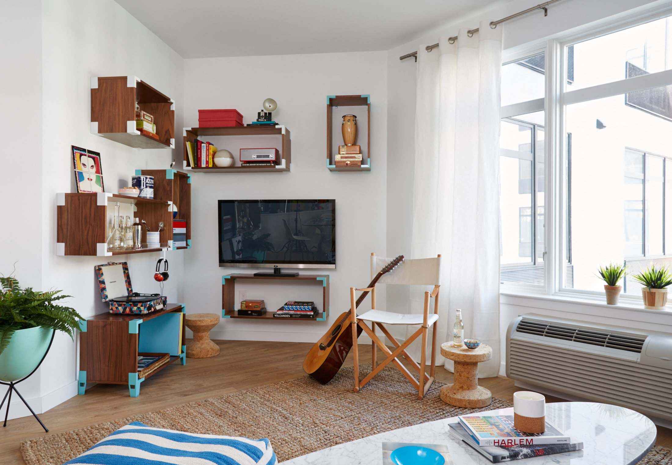 a living room with a television and shelves on the wall