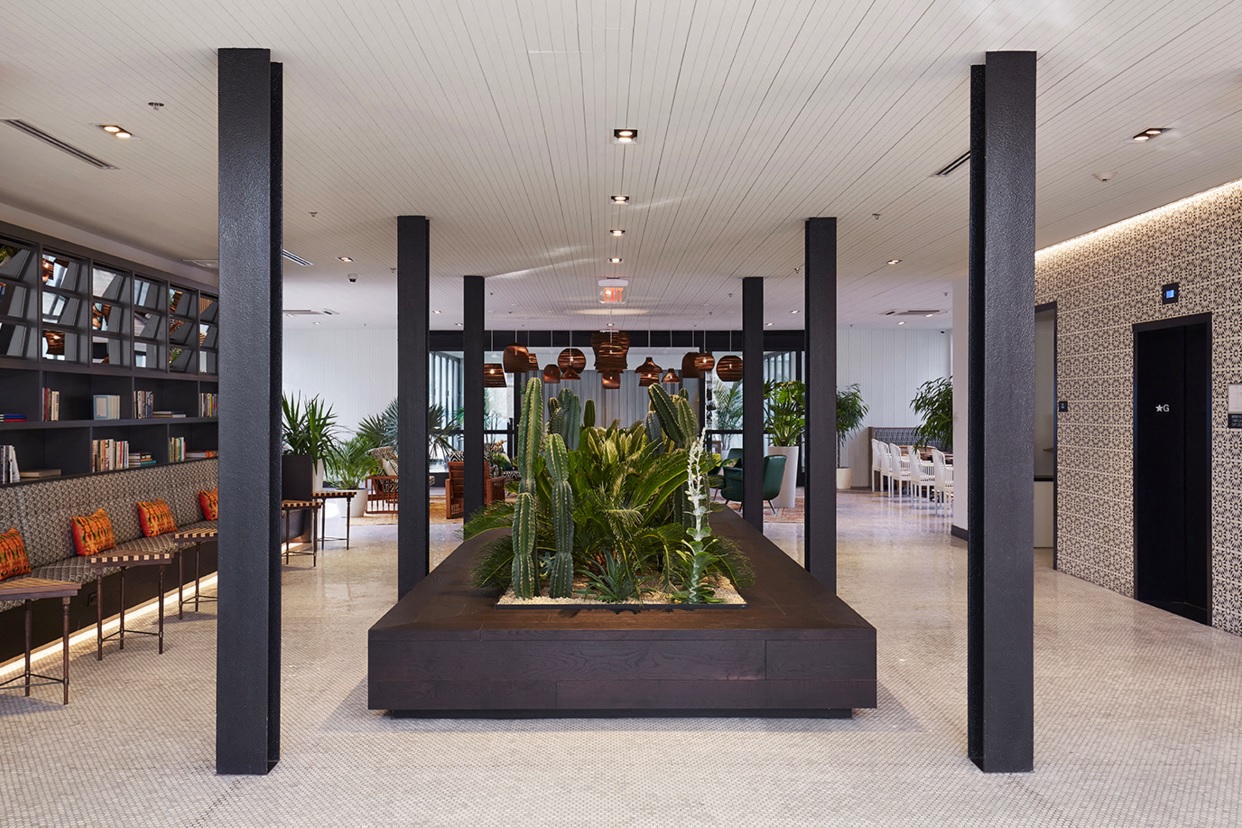 a lobby with a planter of plants in the middle