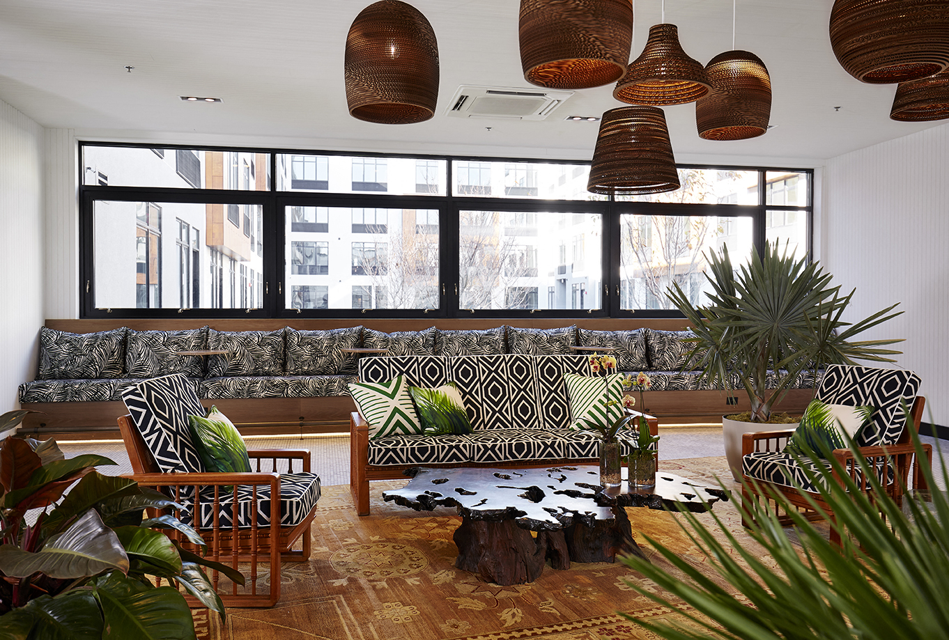 a living room with couches and chairs and large windows