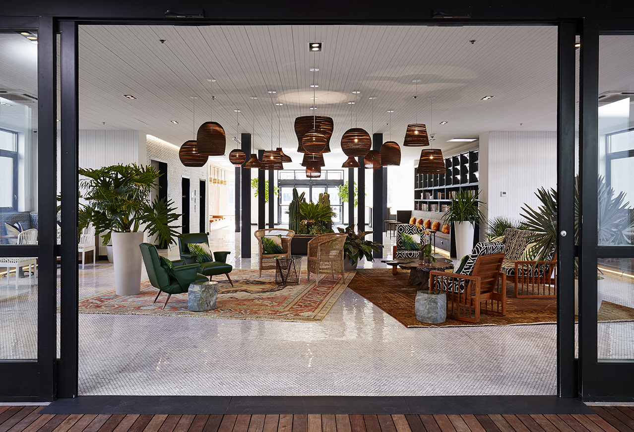 a view of the lobby of a hotel with many chairs and lamps