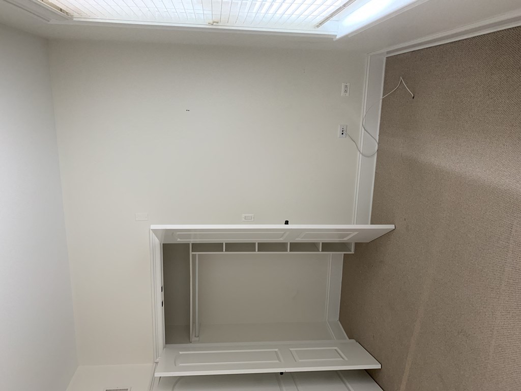 an empty closet in a bathroom with a window