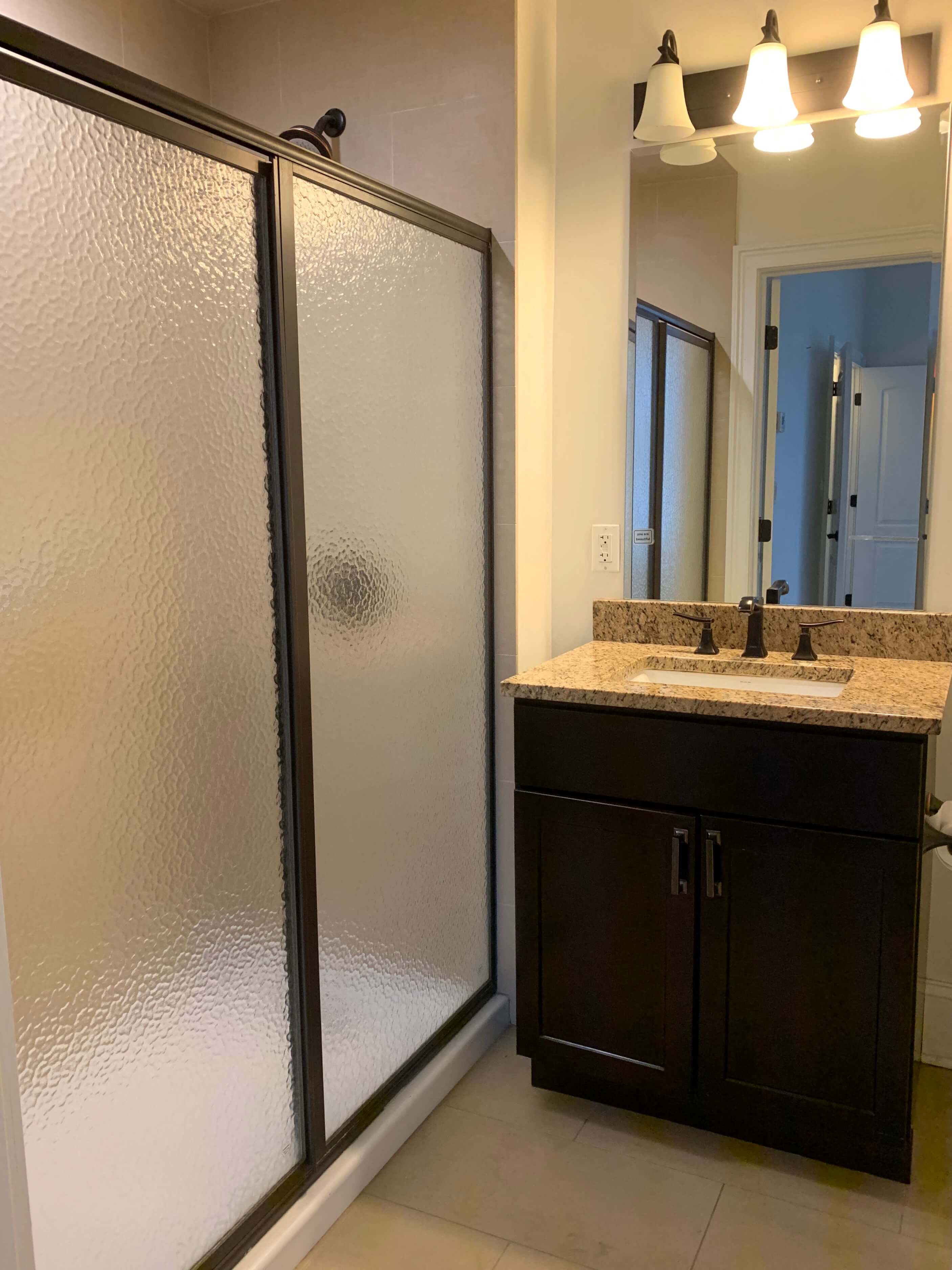 a bathroom with a shower and a sink and a mirror