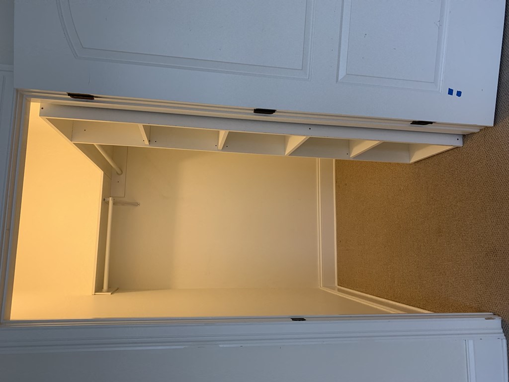 the inside of an open cupboard with a shelf