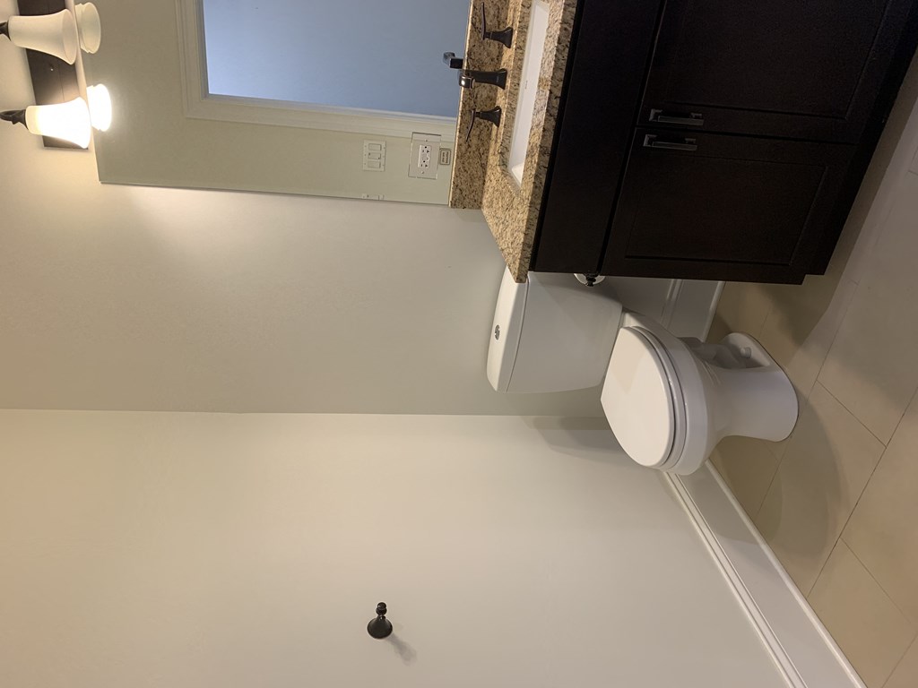 a bathroom with a toilet and a sink and a window