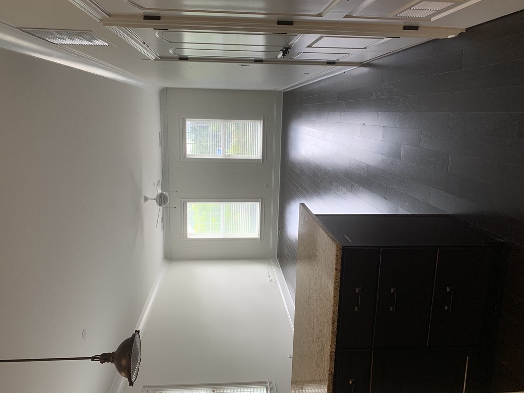 a room with white walls and a window and a dresser