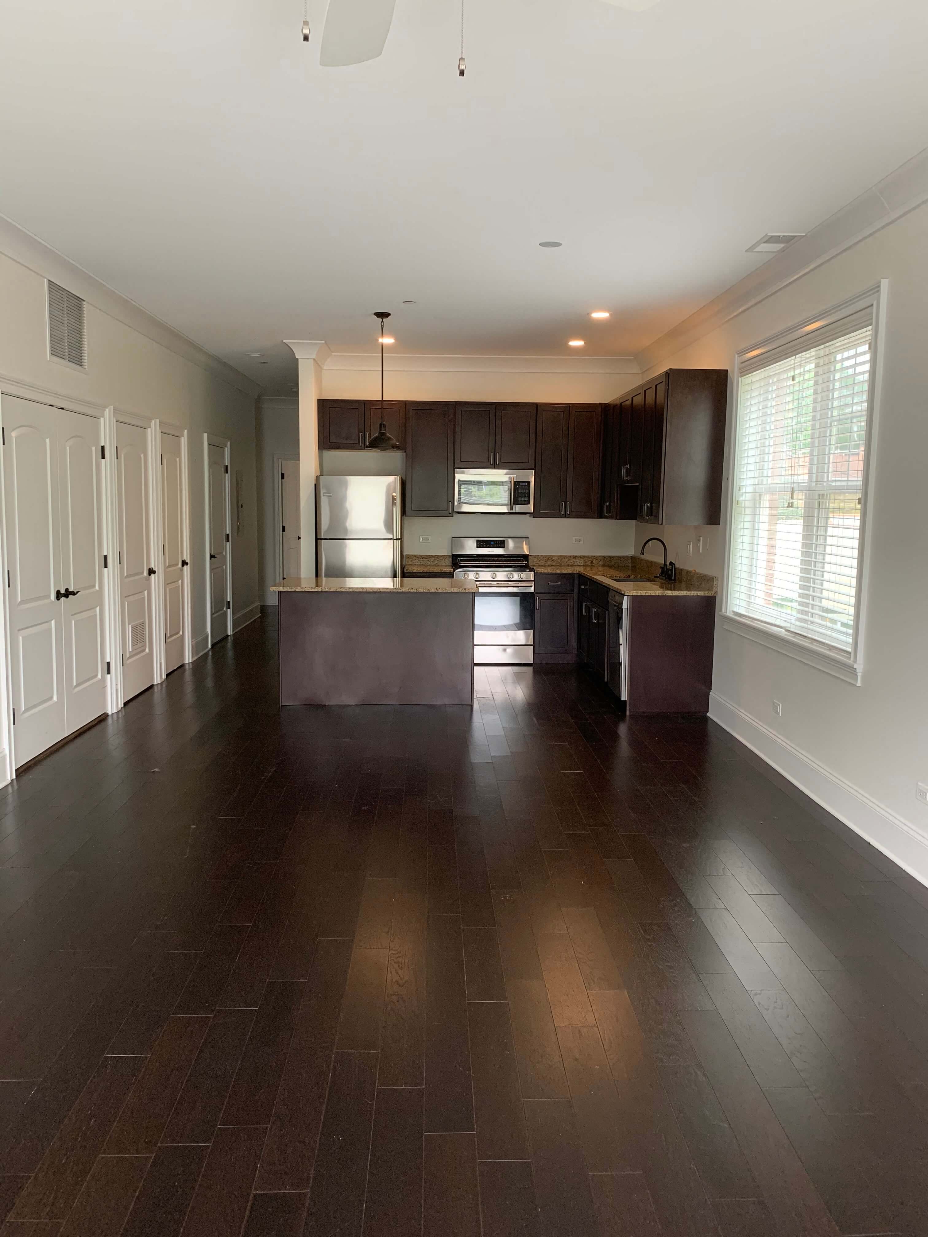 a large empty kitchen with wood flooring and