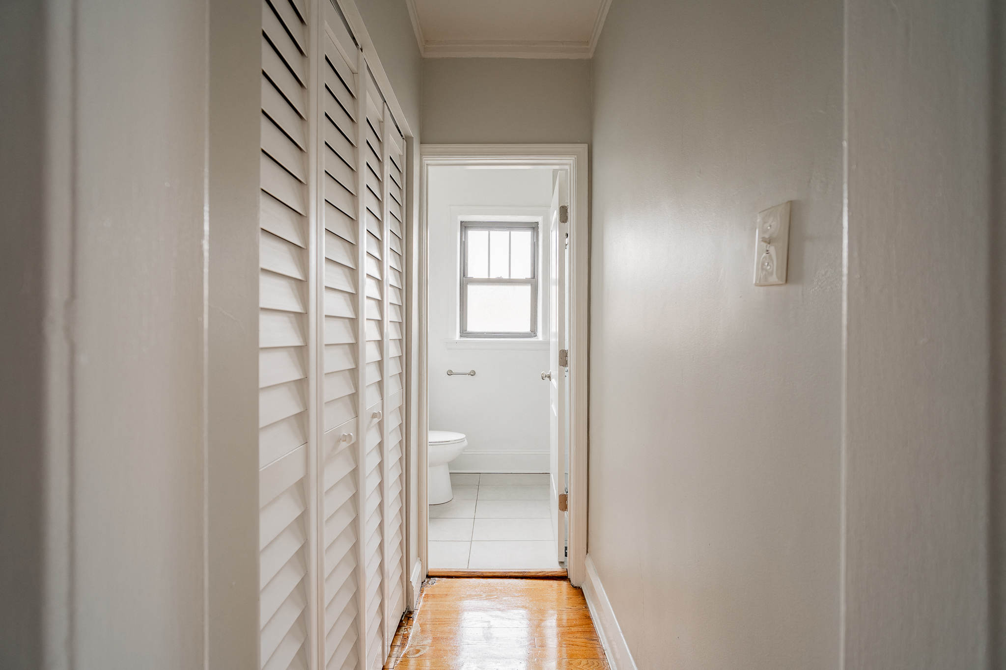 a hallway with a toilet and a window