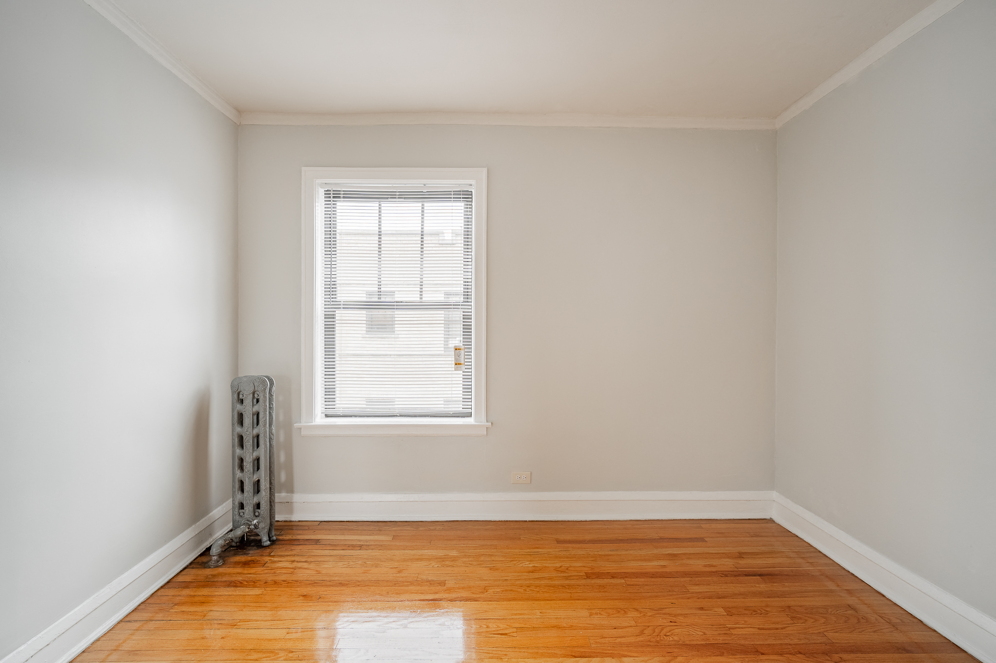 an empty room with wooden floors and a window