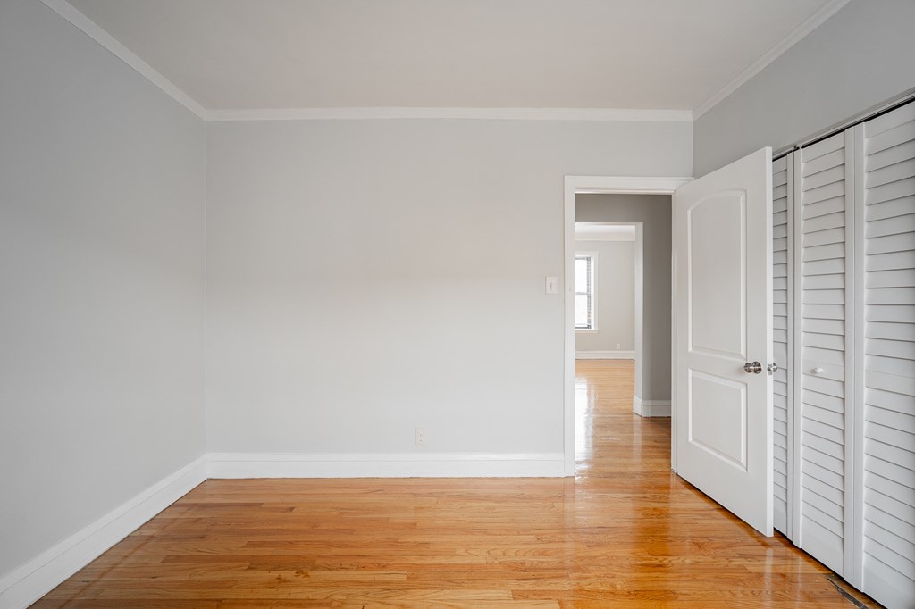 an empty room with wooden floors and white shuttered doors