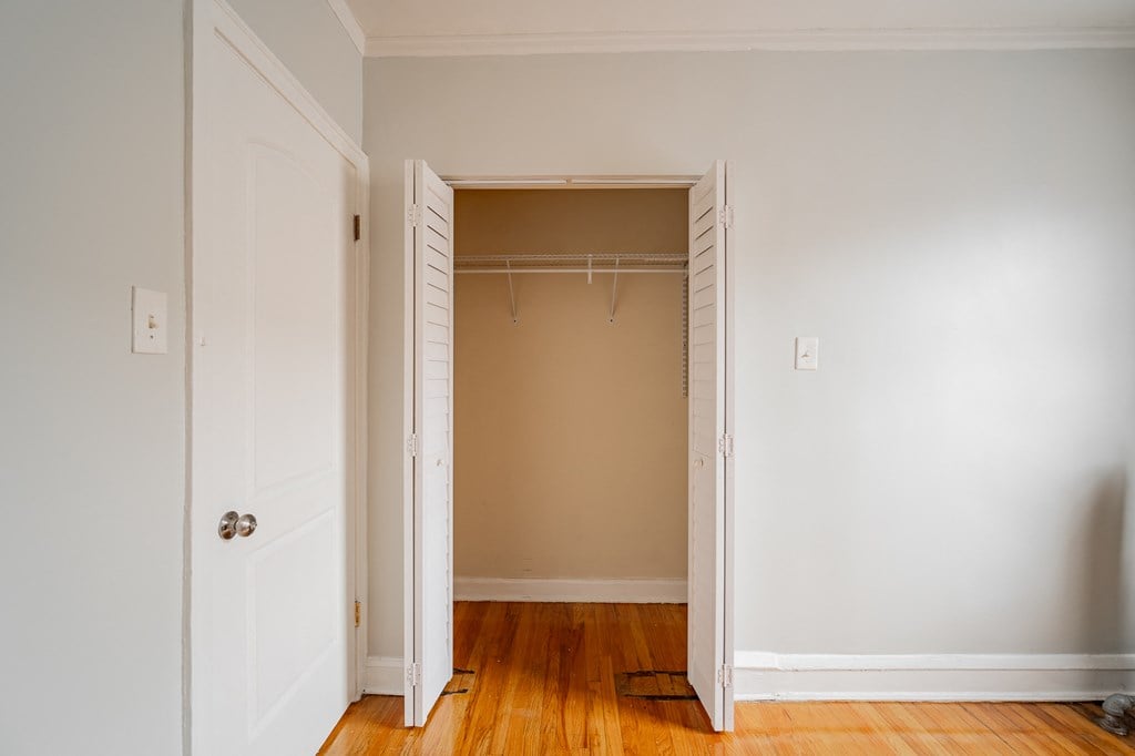 an empty closet in a room with wood floors and white doors