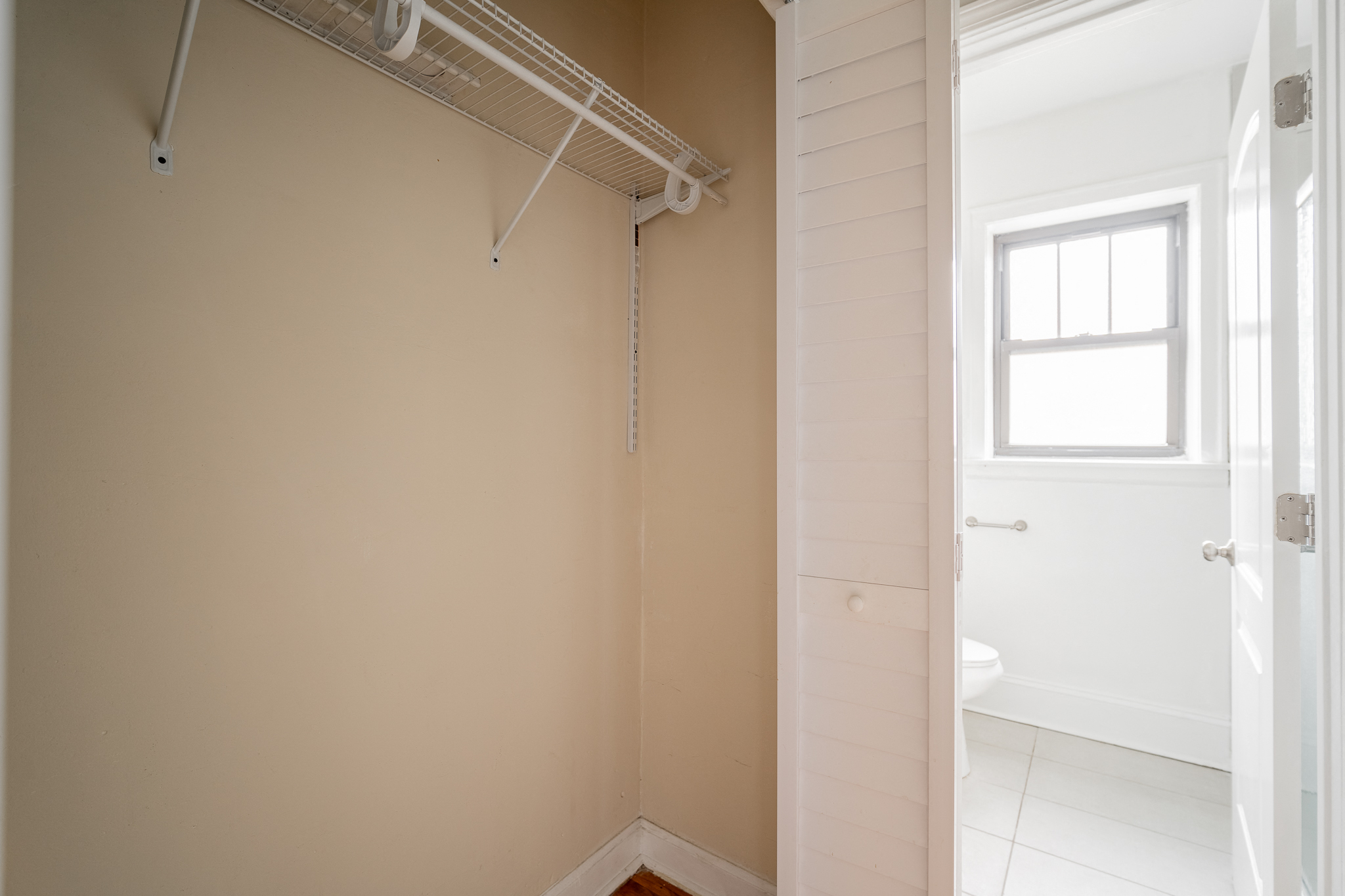 an empty room with a closet and a bathroom with a window