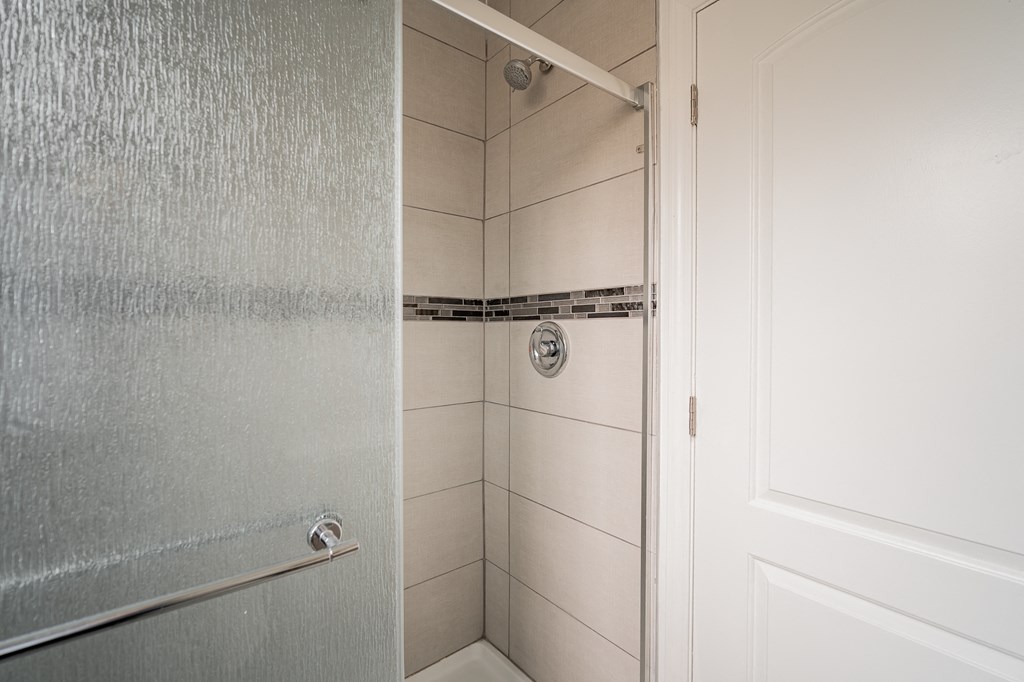 a shower in a bathroom with a sliding glass door
