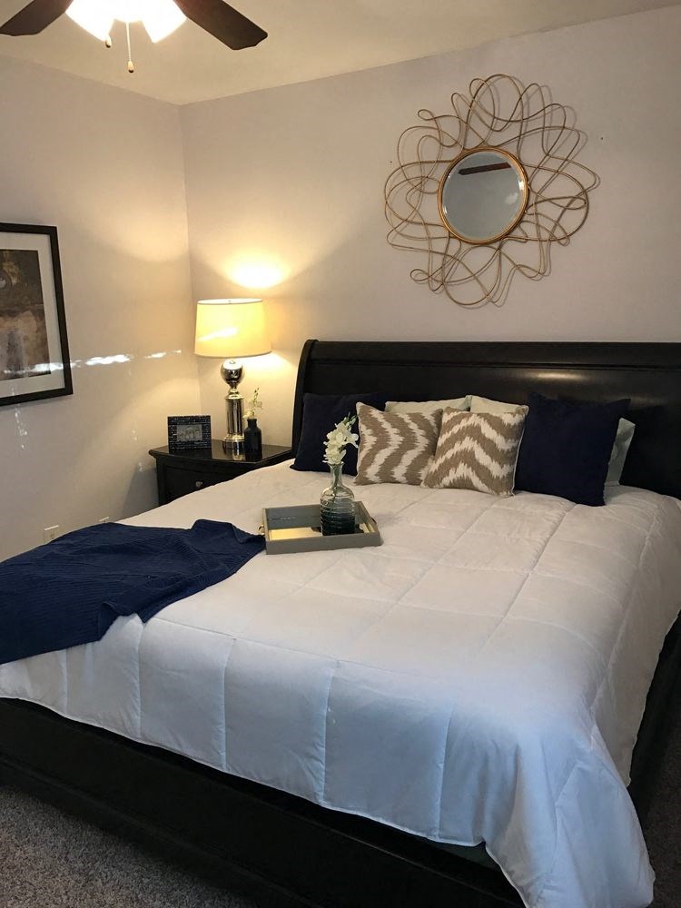 a bedroom with a white bed and a mirror on the wall