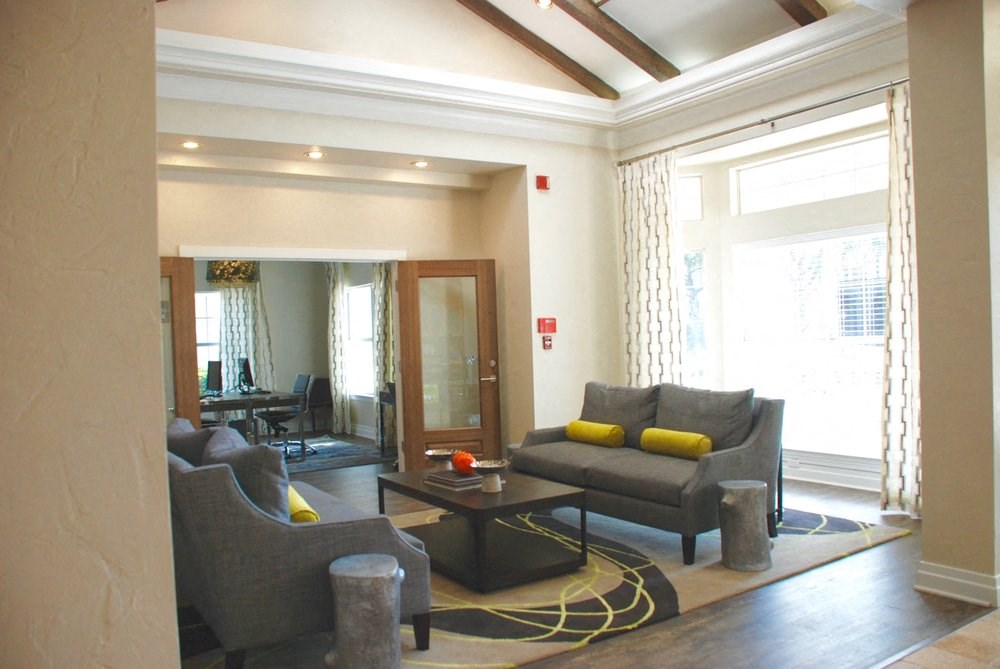 a living room with couches and chairs and a rug