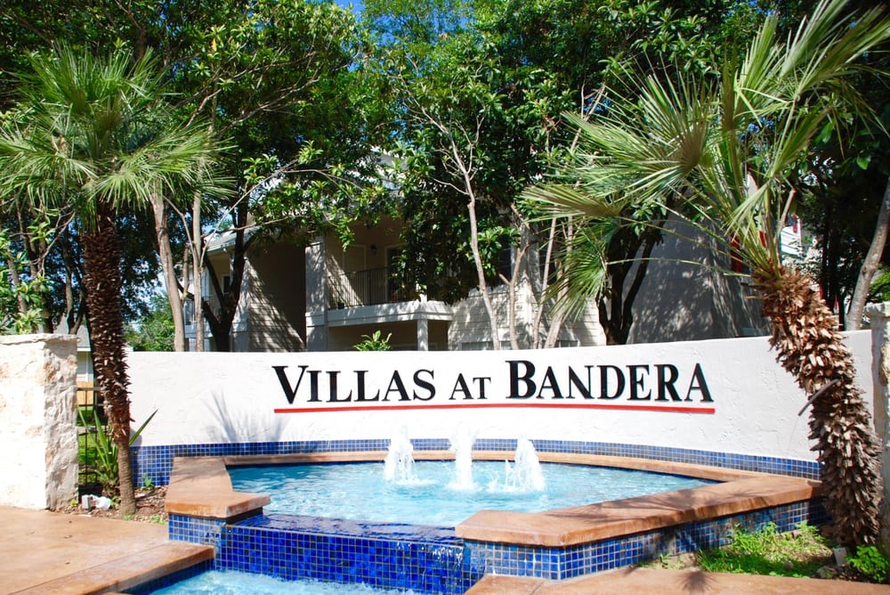 a sign for villas at bandera in front of a swimming pool