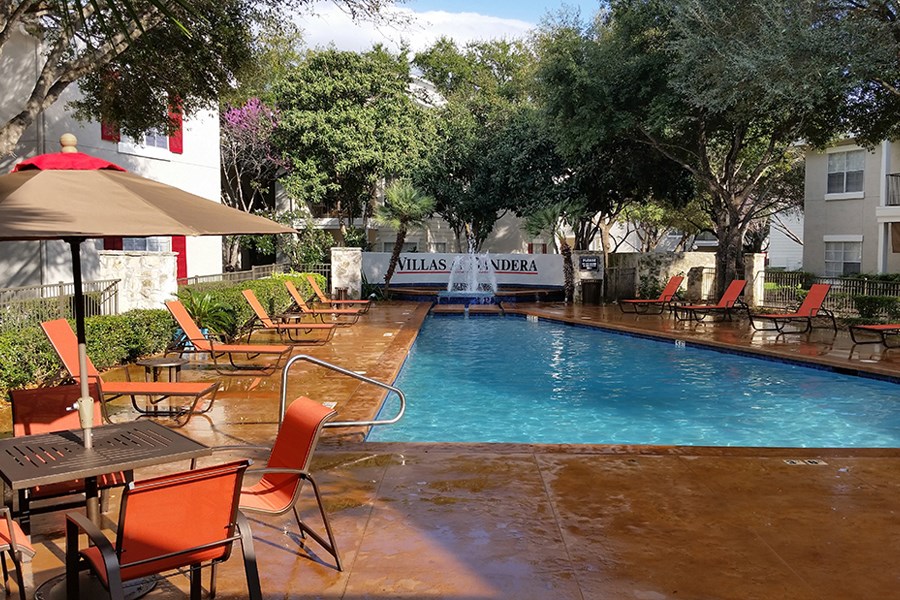 a swimming pool with tables and chairs around it