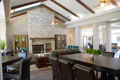 a large living room with a table and chairs and a fireplace