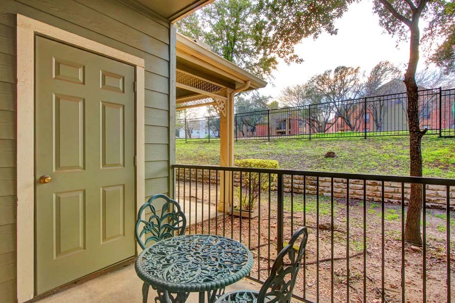 a patio with a table and chairs in front of a house