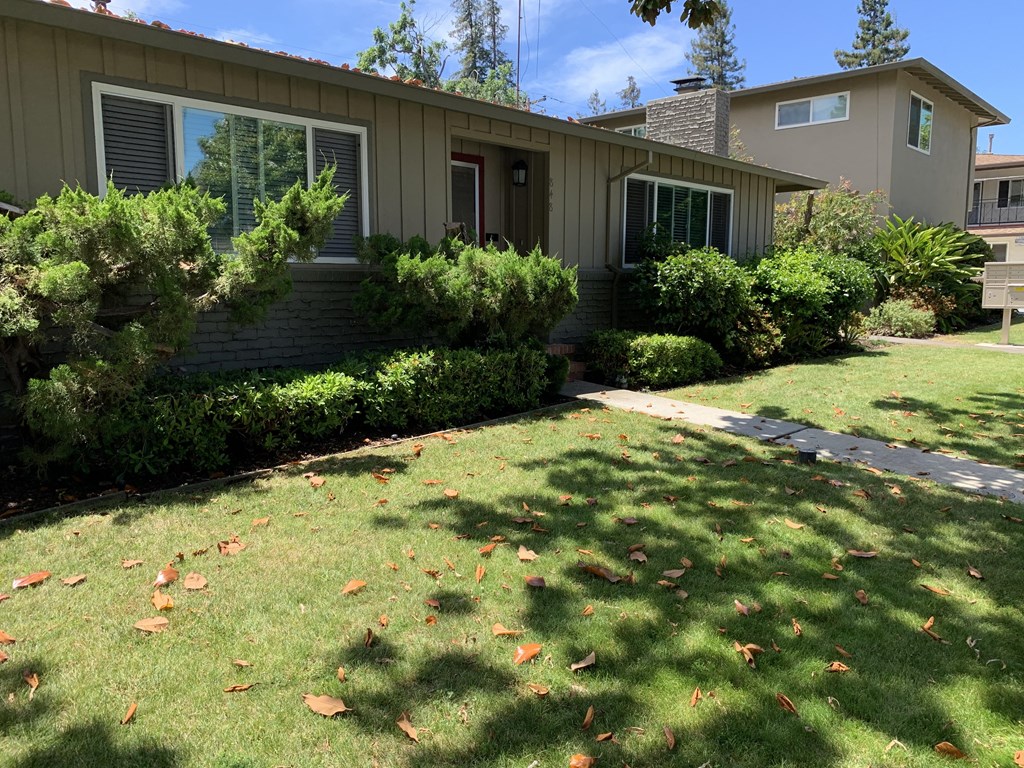 a home with a lawn and a sidewalk in front of it