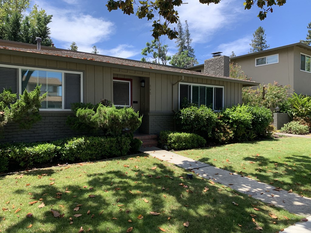 the front of a house with a lawn and walkway