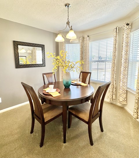 A dining room with a round table and chairs.