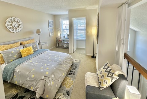A bedroom with a large bed and a couch.