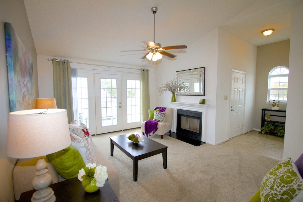 a living room with a fireplace and a ceiling fan