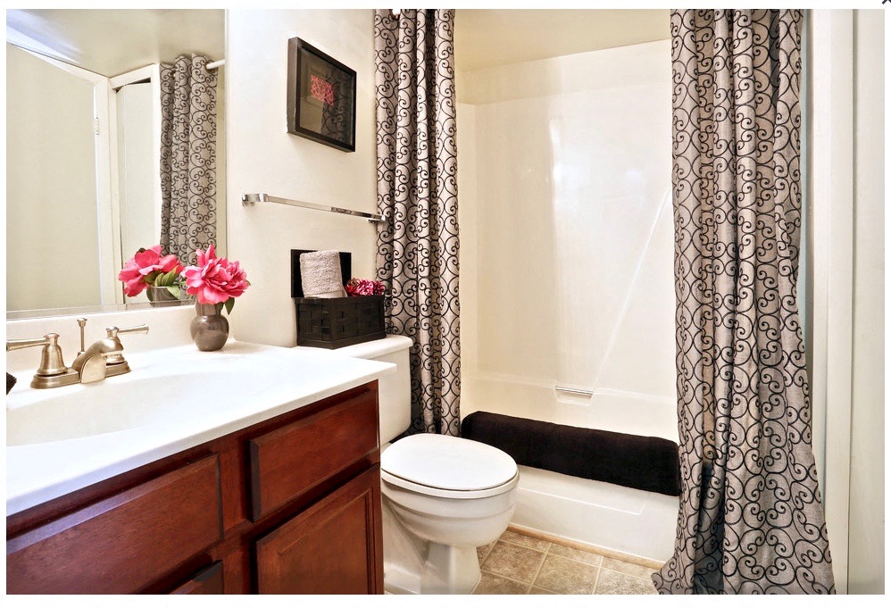 a bathroom with a sink and a toilet and a shower curtain