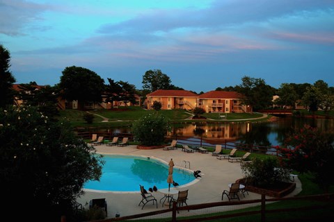 a view of the swimming pool at the resort at dusk