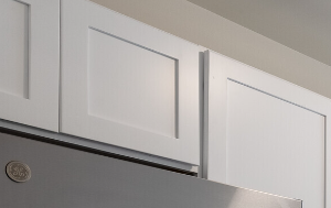 an empty kitchen with stainless steel appliances and white cabinets