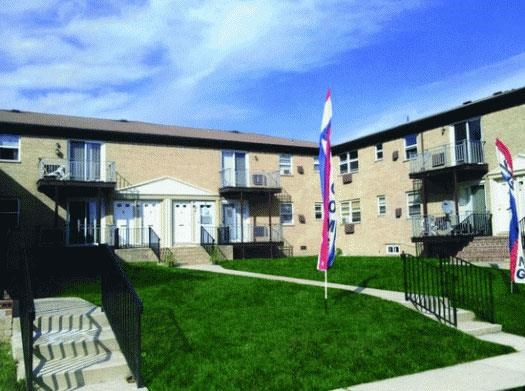 an apartment building with flags in the grass