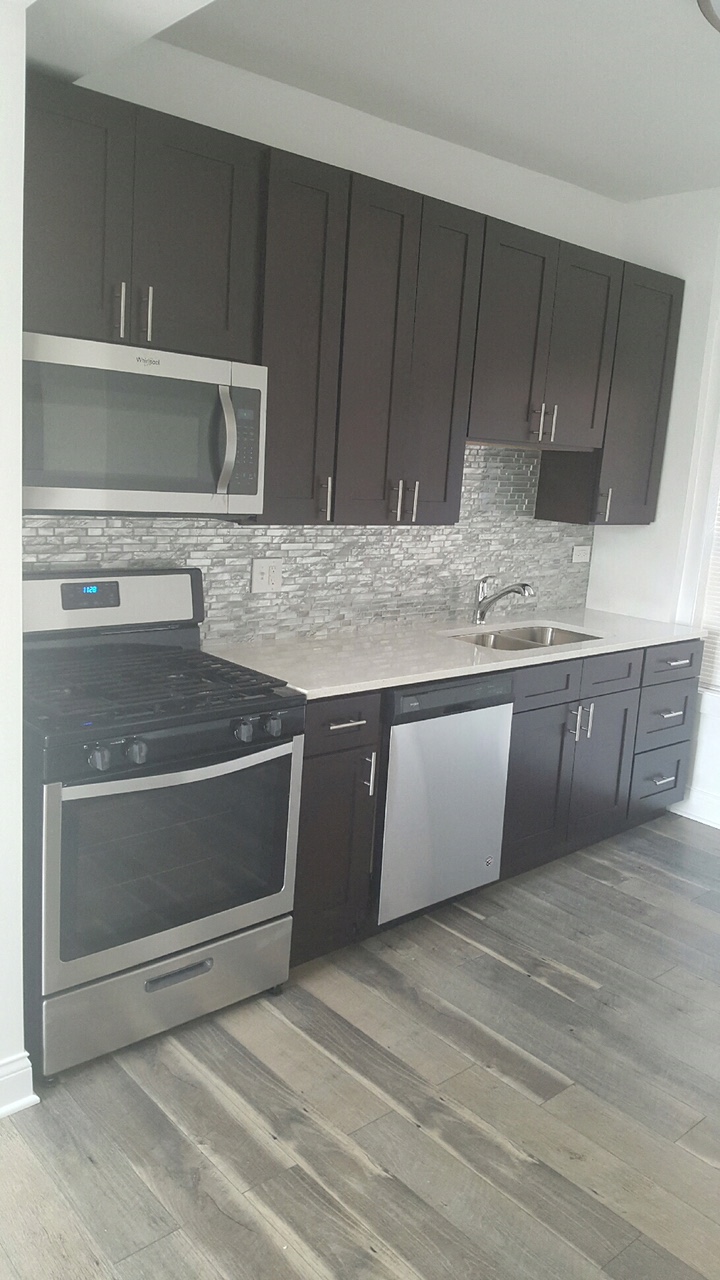 a kitchen with dark cabinets and a stove and a sink