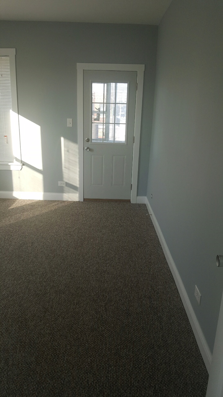 a room with a carpeted floor and a white door