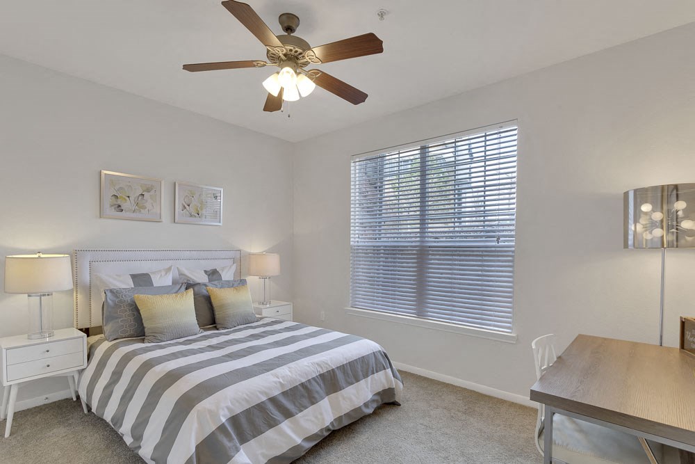 a bedroom with a bed and a ceiling fan