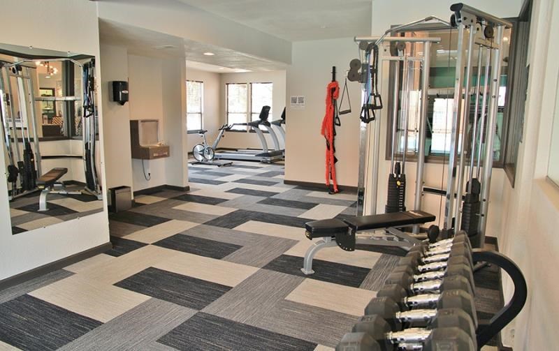 a gym with weights and other equipment in a room
