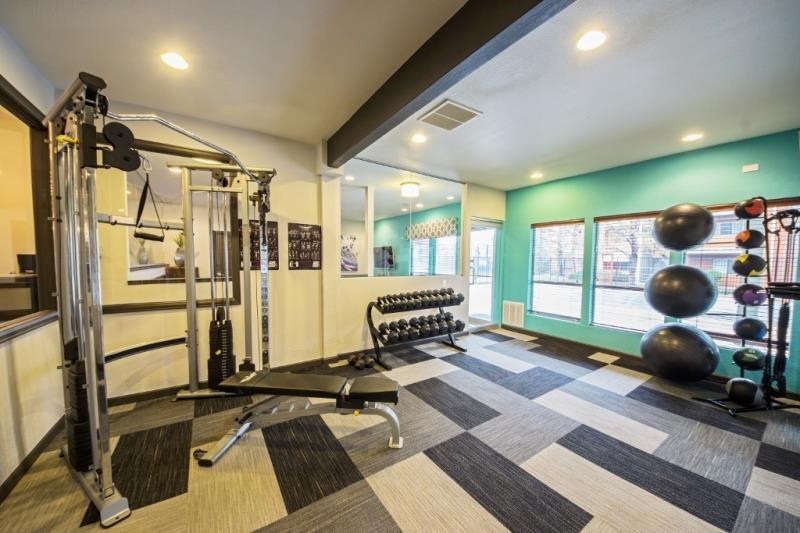 a gym with weights and other equipment and a window