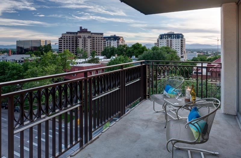 a balcony with a table and chairs and a view of the city