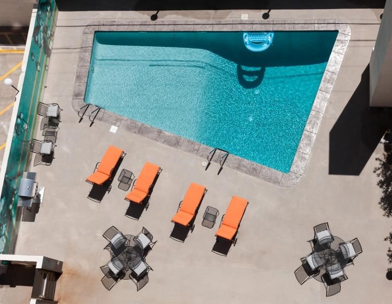 an aerial view of a pool with lounge chairs