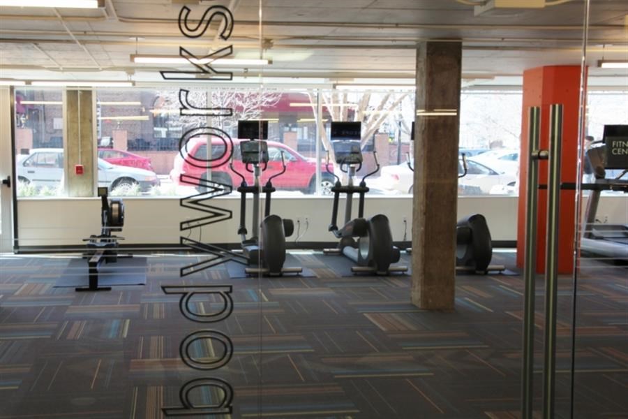 a gym with weights and a window with a view of the street
