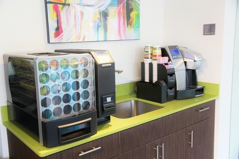 a counter with two coffee machines and a sink