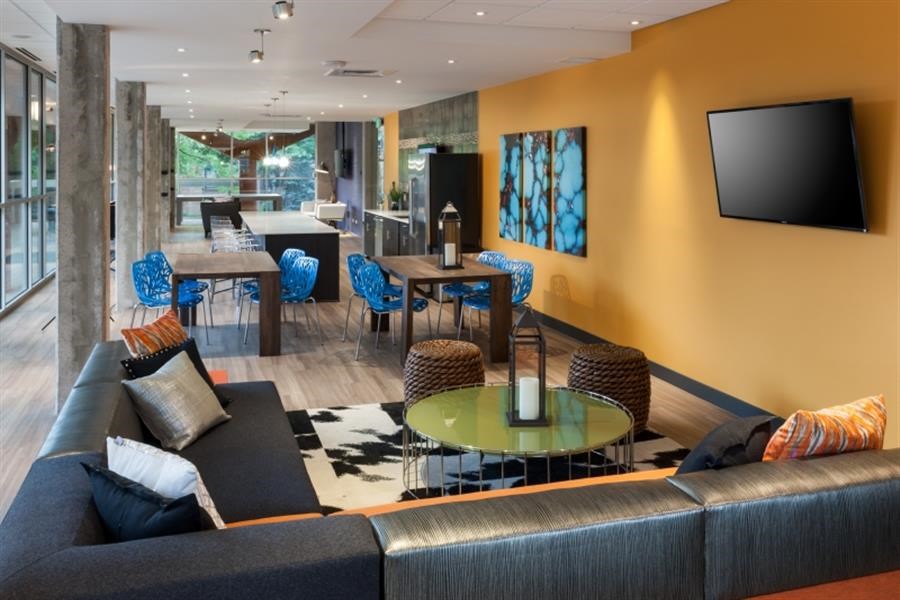 a living room with a couch and tables and a television