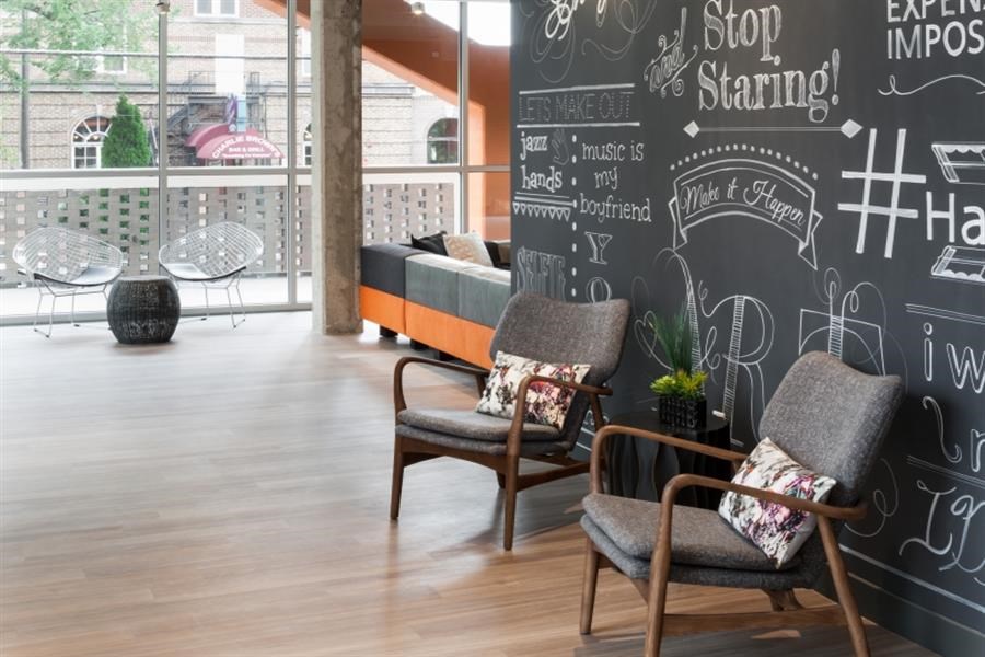the lobby of a building with chairs and a chalkboard wall