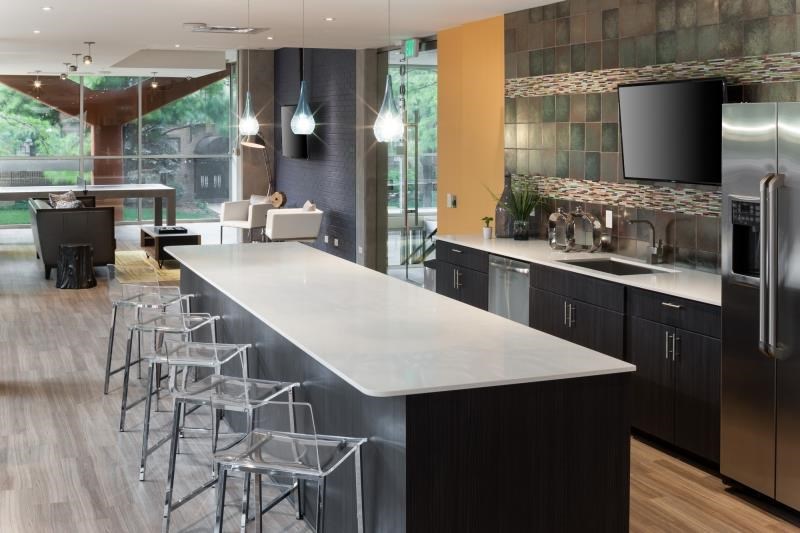 a kitchen with a large white counter top and bar stools