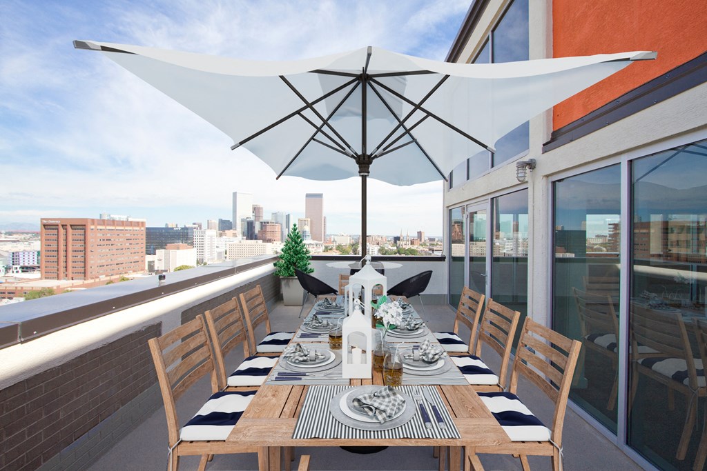 a long dining table on a balcony with a view of the city