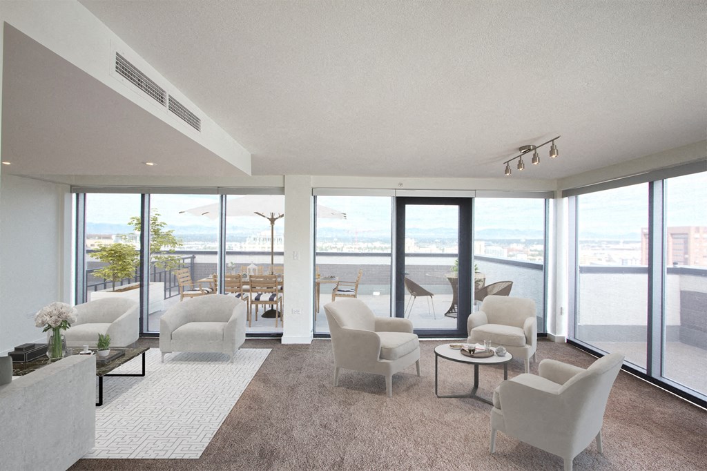 a living room with white chairs and a view of the ocean