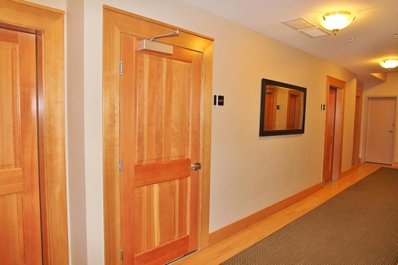 a hallway with two doors and a mirror on the wall