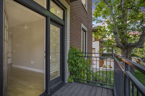 a balcony with a tree and a glass door