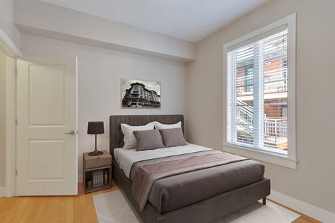 a bedroom with a bed and a large window